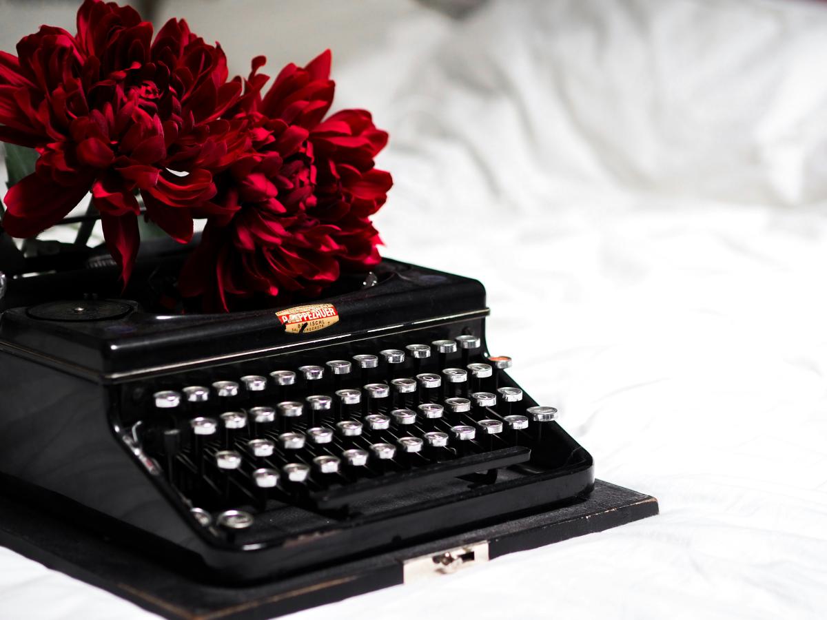 Image of an old fashioned typewriter with roses. Free image from Unsplash.